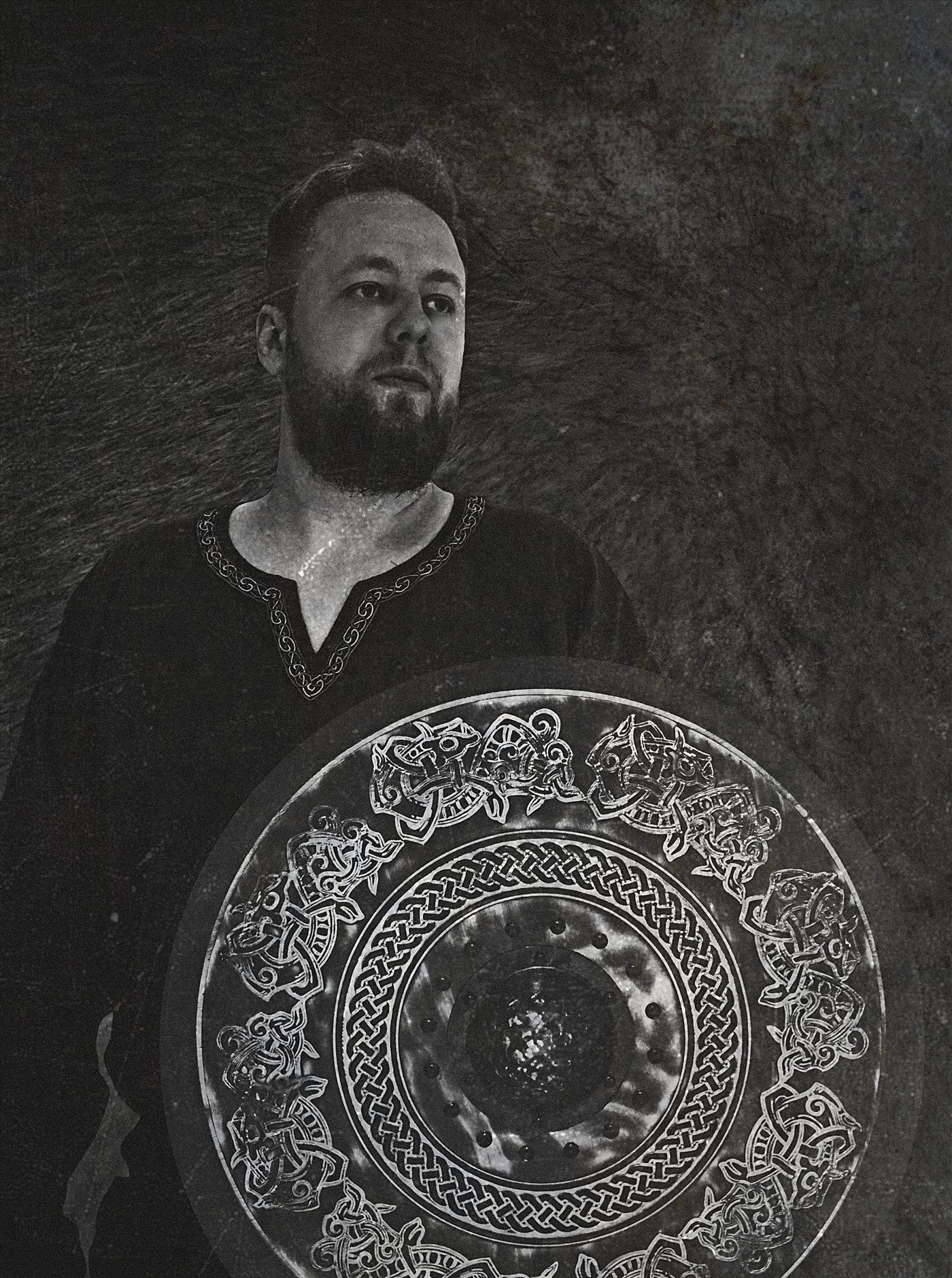 Danheim holding a Viking shield carved with knotwork